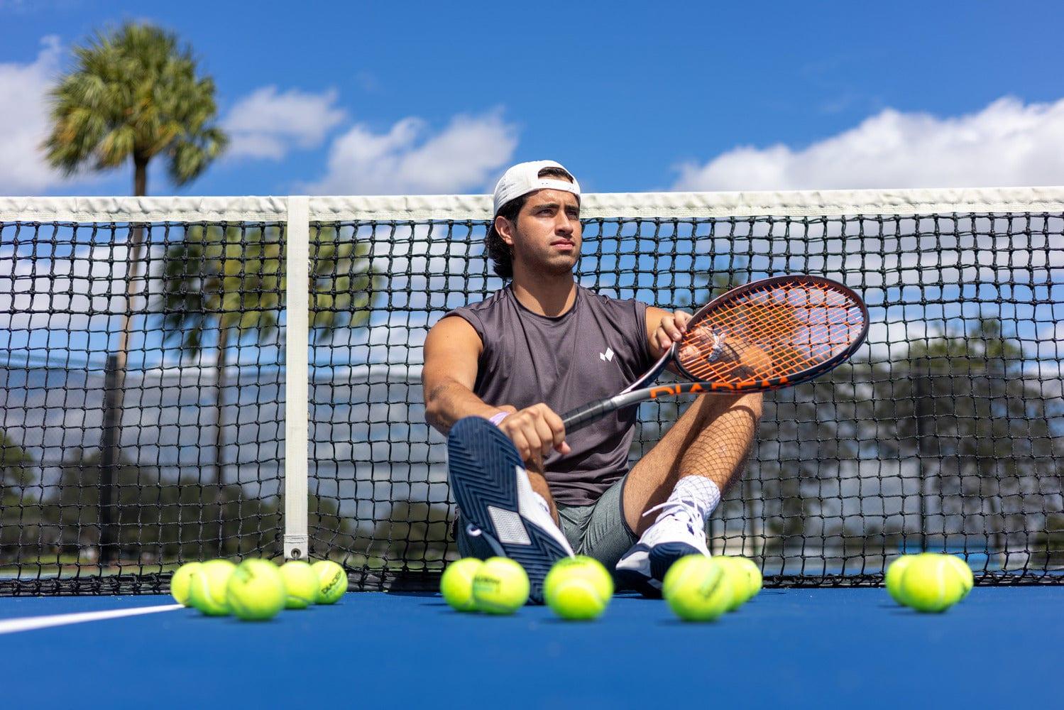 A player sitting at the net with a Diadem racket and tennis balls